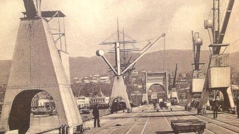 Postal del editor y fotógrafo, Jorge Allan, en la cual se muestra el antiguo Muelle Fiscal desaparecido con la construcción (1912-1927) de las actuales obras del puerto.