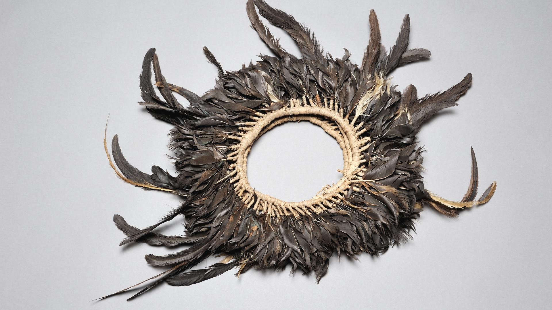 Diadema de plumas elaborado en fibra vegetal (mahute) y plumas negras de gallo.