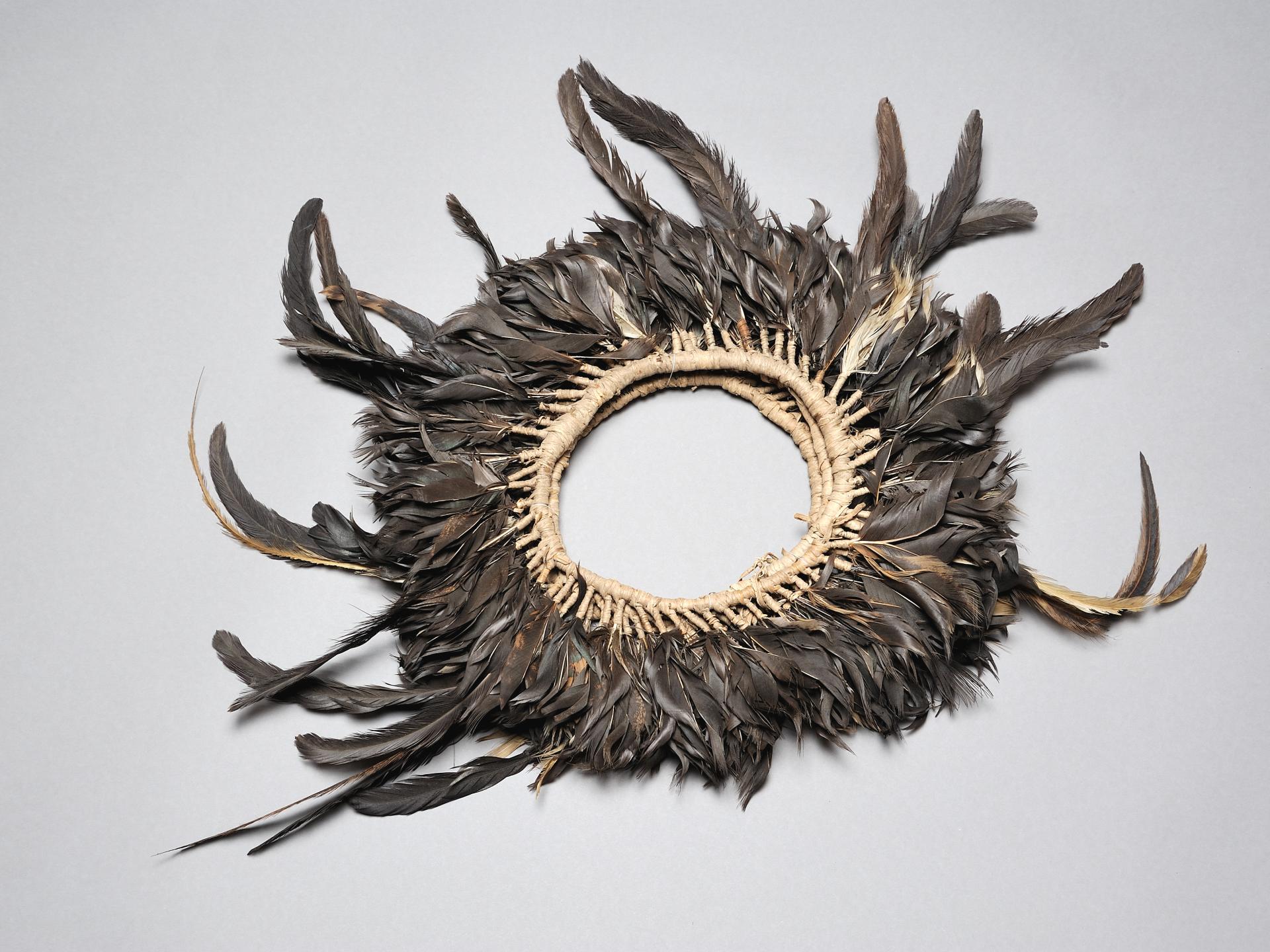Diadema de plumas elaborado en fibra vegetal (mahute) y plumas negras de gallo.