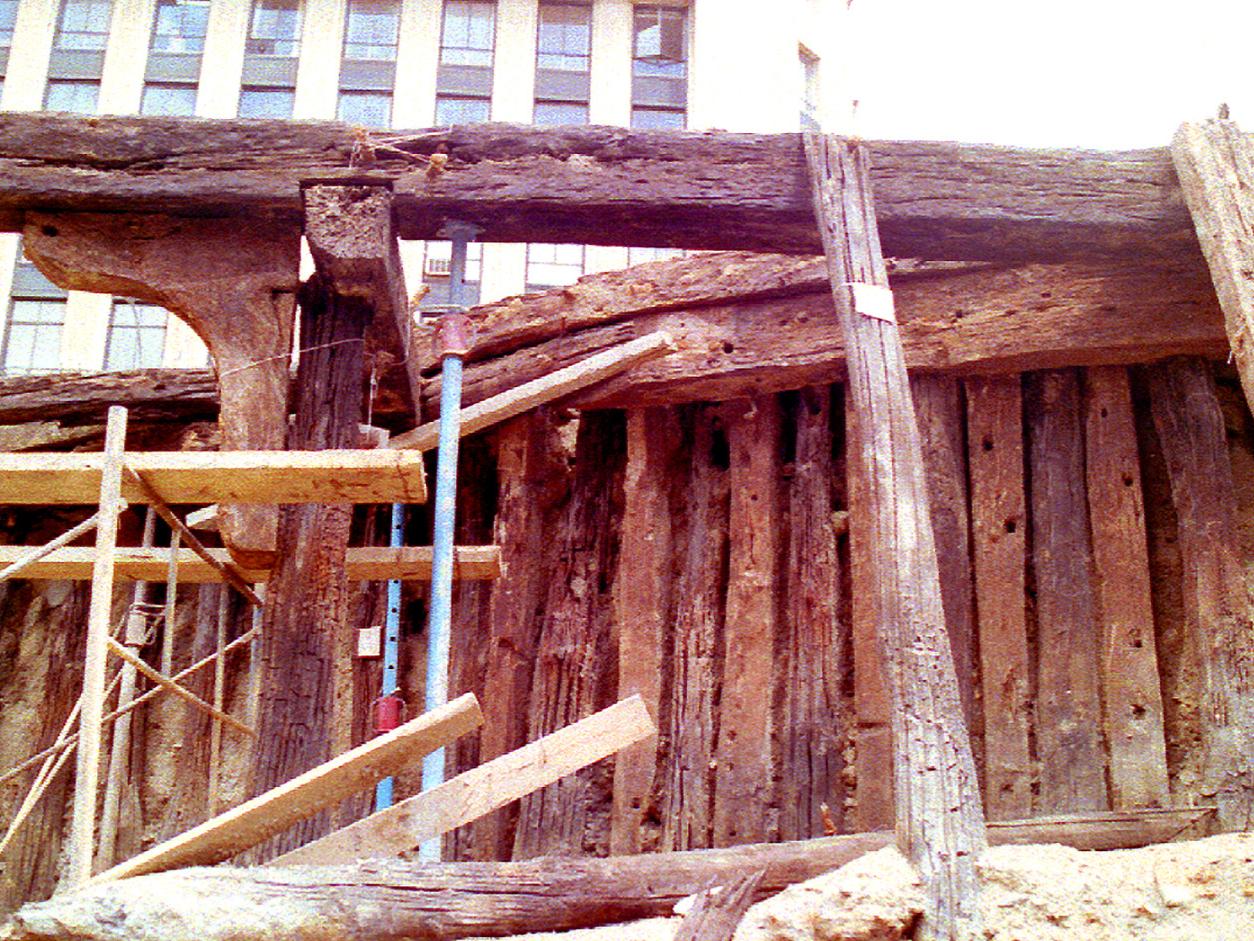 Estructura de madera del primer muelle de Valparaíso donde se aprecian algunas partes de embarcación, correspondiente a la Esmeralda. Fecha 1825.