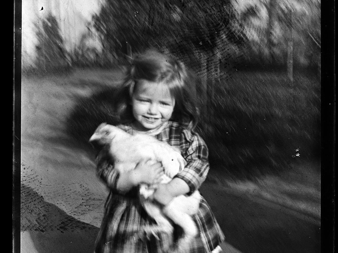 Una niña sosteniendo una gallina