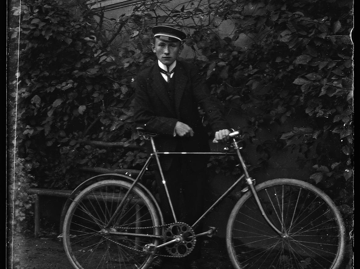 Retrato de un joven uniformado con bicicleta