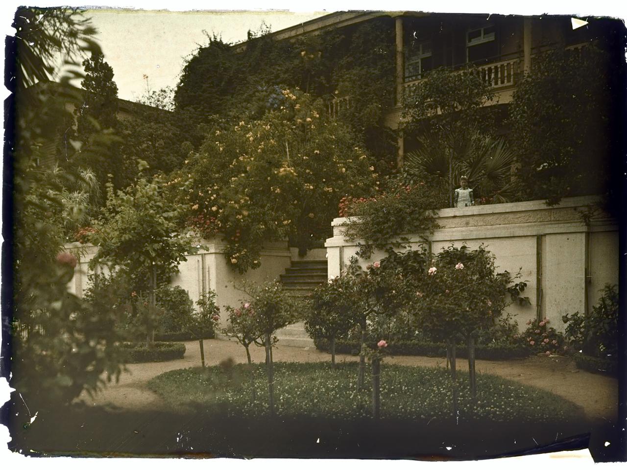 Niña posando en la entrada de una casona
