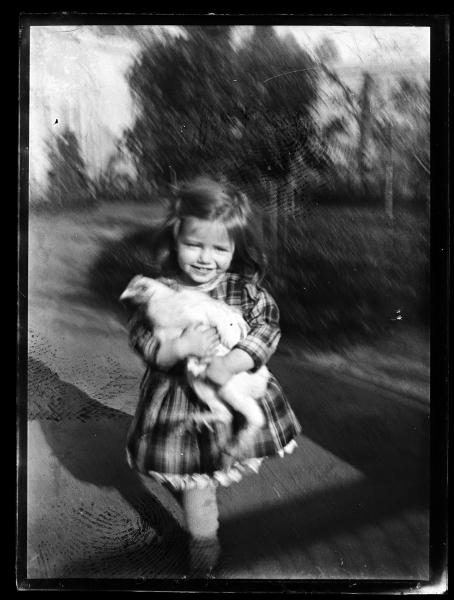 Una niña sosteniendo una gallina