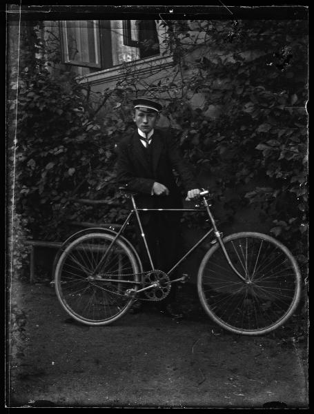 Retrato de un joven uniformado con bicicleta
