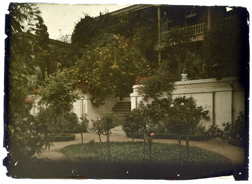 Niña posando en la entrada de una casona